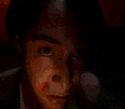 a close up of a person 's face with their mouth open in a dark room