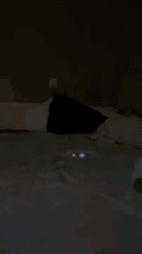 a person is laying on a bed in the dark with a red light coming out of the corner .