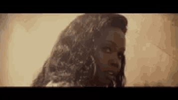 a close up of a woman 's face with long hair and a serious look on her face .