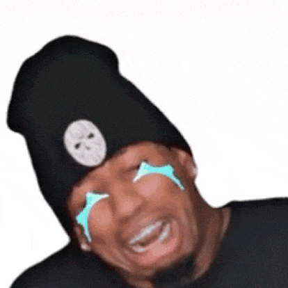 a man wearing a black beanie and a black shirt is crying with tears coming out of his eyes .