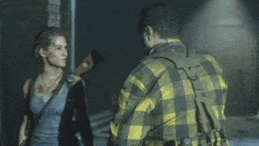 a man in a plaid shirt is standing next to a woman in a blue tank top