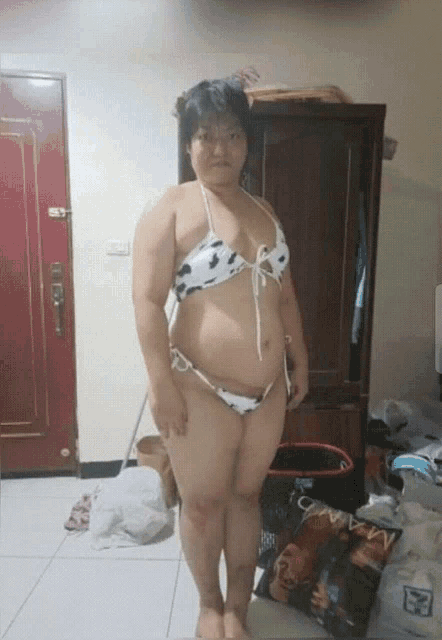 a woman in a bikini stands next to a bag of chips