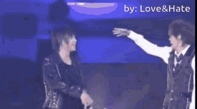 a couple of people are dancing on a stage and the words love & hate are on the bottom