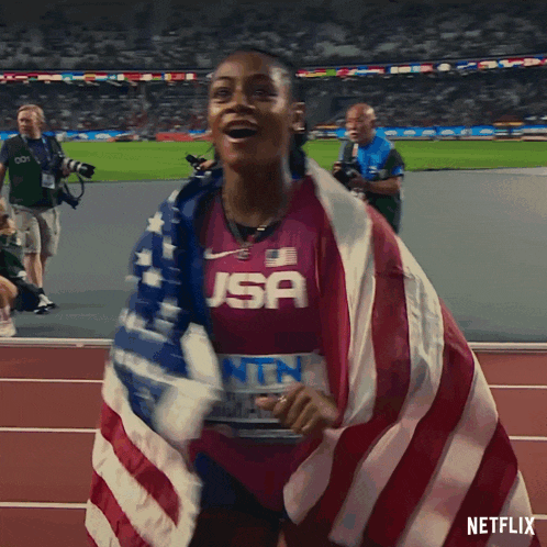a woman wearing a jsa shirt is wrapped in an american flag