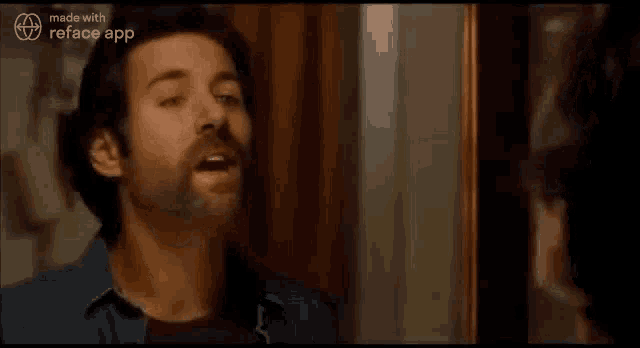 a man with a beard is looking at himself in a mirror and smiling .