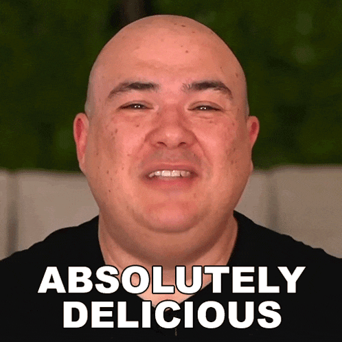 a bald man is smiling with the words absolutely delicious above him