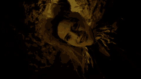a woman with a bun on her head is smiling in a dark room
