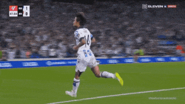 a soccer player with the number 14 on his jersey is running on the field