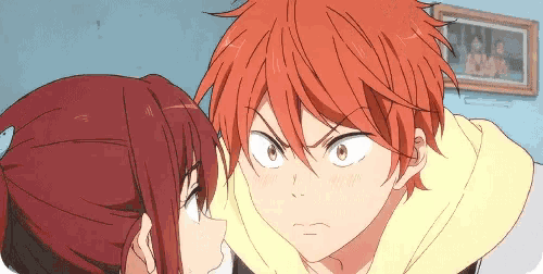 a boy with red hair is kissing a girl on the cheek