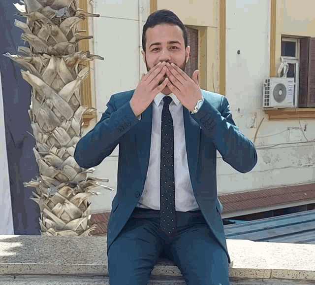 a man in a suit and tie is covering his mouth
