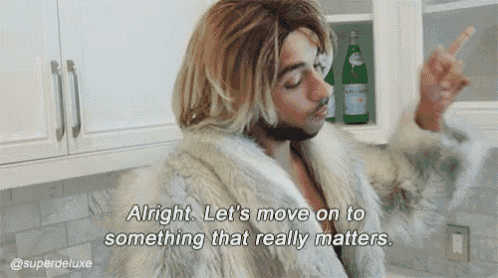 a man in a fur coat is pointing up and saying alright let 's move on to something that really matters .