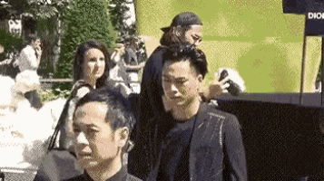 a group of people are standing next to each other in a crowded street .