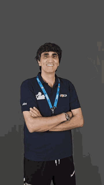 a man wearing a blue shirt with a lanyard around his neck that says ' lions ' on it