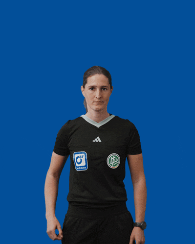 a woman wearing a black adidas shirt holds a yellow card