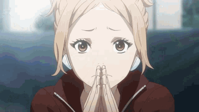 a close up of a girl with her hands folded in prayer