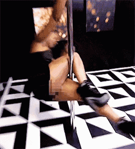 a woman is dancing on a pole in a room with a black and white checkered floor .