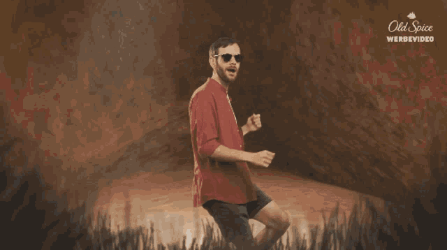 a man wearing sunglasses is dancing in front of an old spice advertisement