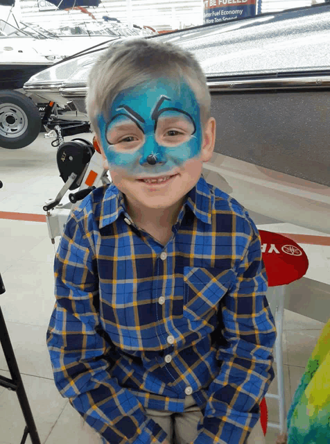 a young boy with his face painted in blue and black