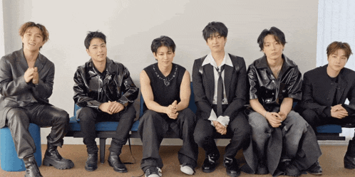 a group of young men are sitting in a row