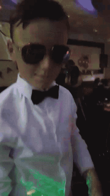 a young boy wearing a bow tie and sunglasses