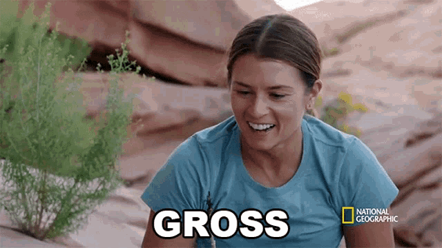 a woman in a national geographic shirt is smiling