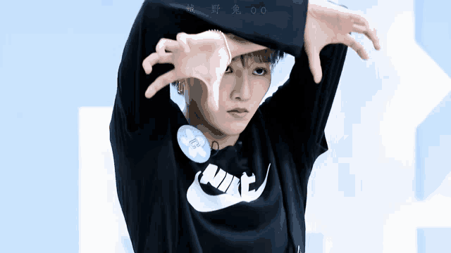 a person wearing a black nike shirt is making a funny face