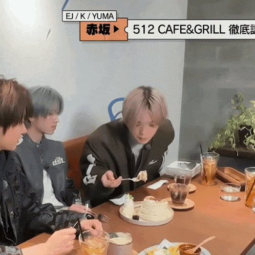 a group of people are sitting at a table with a sign that says 512 cafe & grill on it