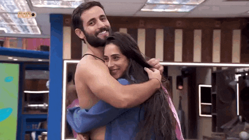 a man is hugging a woman in a room .