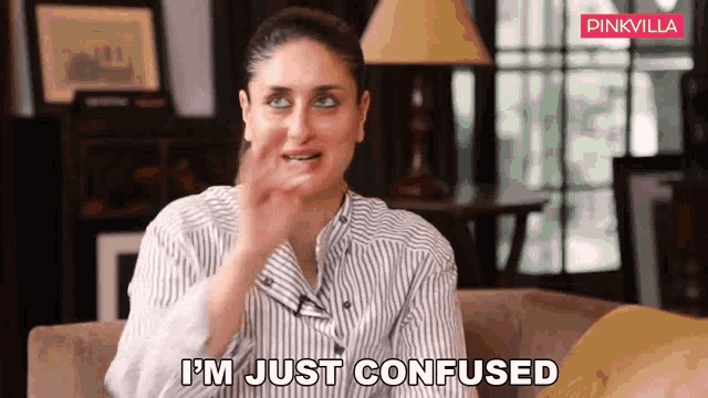 a woman is sitting on a couch making a funny face and saying i 'm just confused .