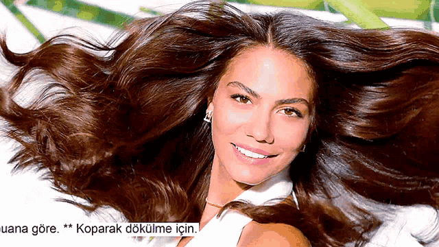 a woman is smiling with her hair blowing in the wind and the words " koparak dokume için " are below her