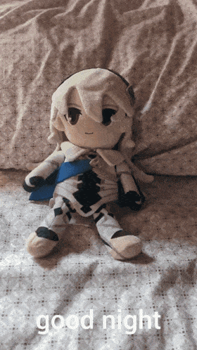 a stuffed animal is laying on a bed with the words good night written on the bottom