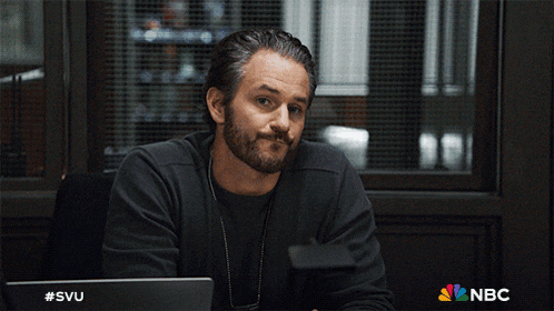 a man sitting in front of a laptop with #svu on it