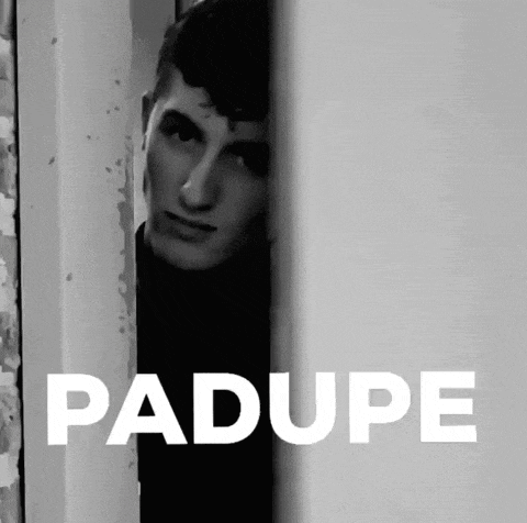a black and white photo of a man peeking out from behind a wall with the word padupe in white