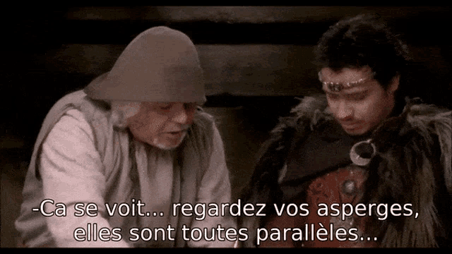 a man in a hat talks to another man with the words regardez vos asperges