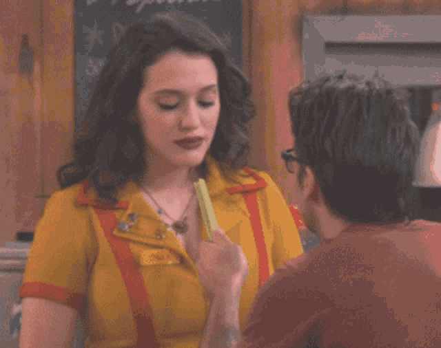 a woman in a yellow and red uniform has a name tag that says maggi