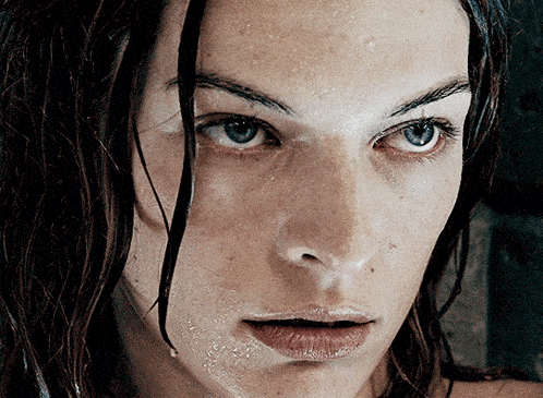 a close up of a woman 's face with water drops on her face