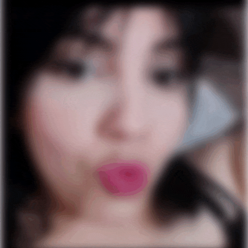 a blurry picture of a woman 's face with pink lipstick