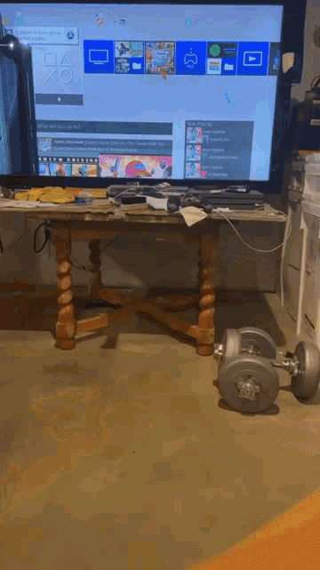 a dumbbell sits on the floor in front of a playstation 4