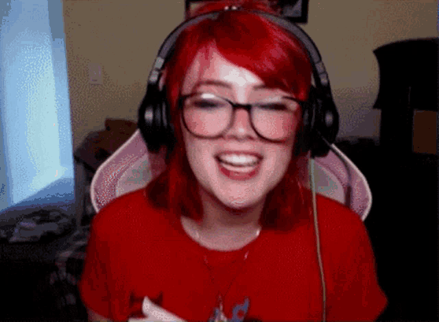 a girl with red hair and glasses wearing headphones