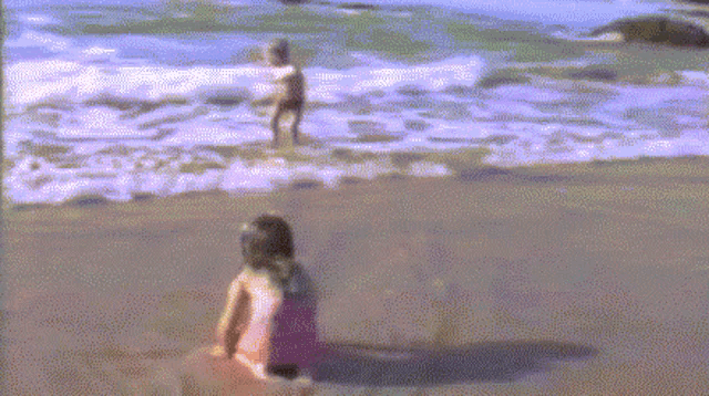 a boy and a girl are playing on a beach