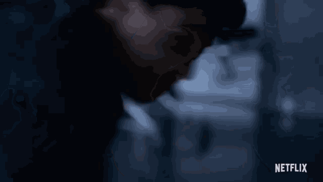 a close up of a person 's face in a dark room with a netflix logo in the bottom right corner .