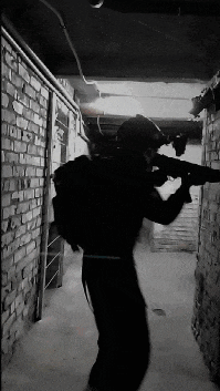 a black and white photo of a man holding a rifle