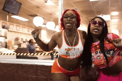 two women are posing for a picture and one is wearing a hooters outfit
