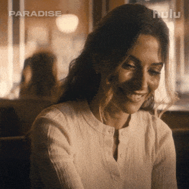 a woman in a white shirt is smiling in a scene from paradise
