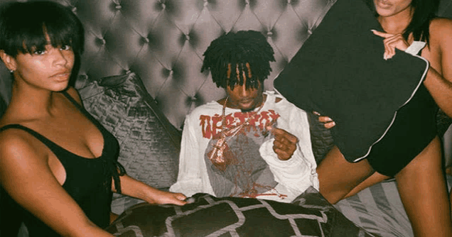 a man wearing a shirt that says destroy is surrounded by two women on a bed