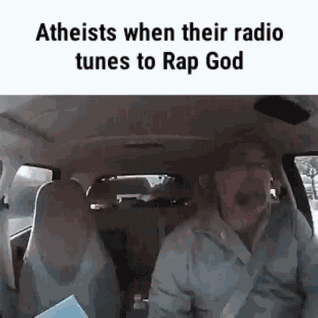 a man is sitting in the back seat of a car talking to another man .