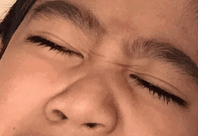 a close up of a person 's face with his eyes closed