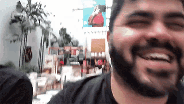a man with a beard is smiling in front of a sign that says ' abercrombie & fitch '