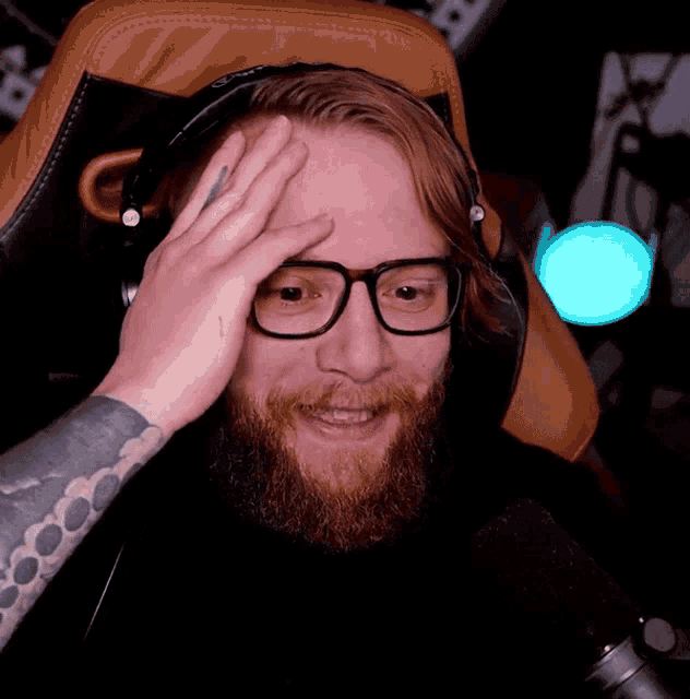 a man with glasses and a tattoo on his arm