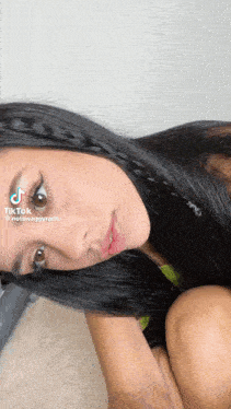a woman with long black hair has a braid in her hair and has a tiktok account